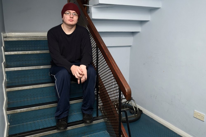 Young Man Red Cap Stairs Seated Centered Horizontal 1000X667