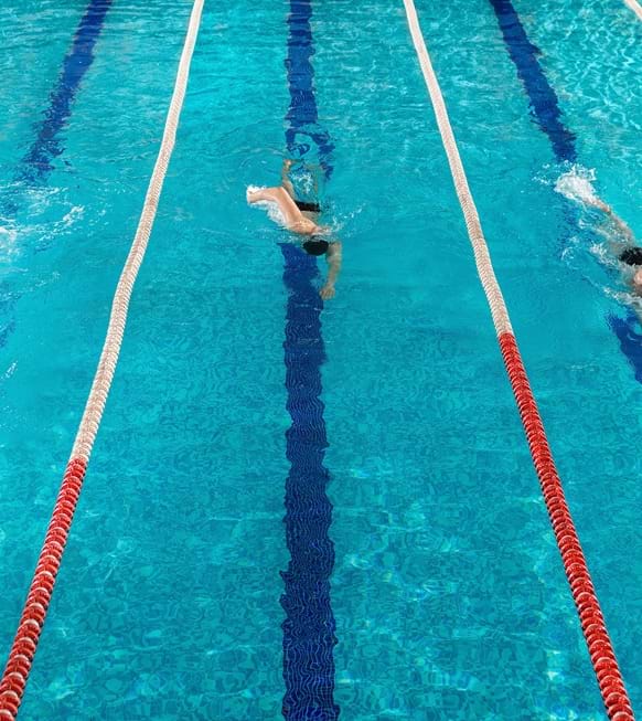 Three Male Swimmers Racing Against Each Other